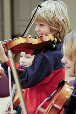 Blonder Junge spielt Geige in einer Gruppe. Foto: Landesverband niedersächsischer Musikschulen