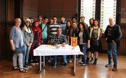 Empfang einer Gruppe israelischer Schülerinnen und Schüler durch Bürgermeisterin Eilers-Dörfler. Foto: Stadt Oldenburg Eine Gruppe Jugendliche und ihre Lehrkräfte steht um einen Tisch. Am Tisch sitzt ein Mann und trägt sich in das Gästebuch ein. Foto: Stadt Oldenburg