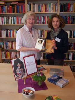 Zwei Frauen stehen vor einer Bücherwand und präsentieren Bücher. Foto: Stadt Oldenburg