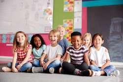 Kinder sitzen auf dem Boden. Foto: Monkey Business / Adobe Stock