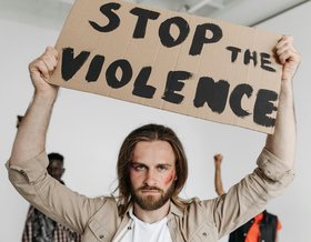 Ein Mann hält ein Schild hoch mit Aufschrift „Stop the Violence“ Foto: Pavel Danilyuk/pexels