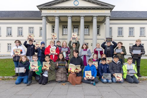 Präsentieren zur KIBUM-Eröffnung gemeinsam philosophische Gedanken und Geschichten: Illustratorin und Autorin Antje Damm mit Schülerinnen und Schülern der Grundschule Klingenbergstraße. Foto: Martin Remmers