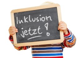 Kind hält eine Tafel mit der Aufschrift „Inklusion jetzt!“ Foto: Robert Kneschke/Fotolia.de