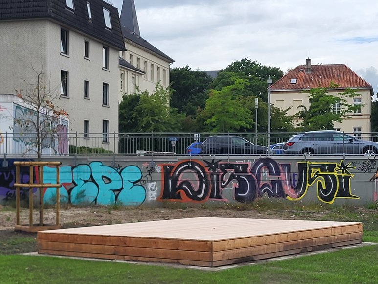 Das fertiggestellte Holzpodest vor der Wand mit Graffiti. Foto: Stadt Oldenburg