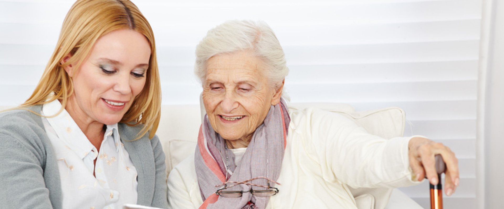 Eine Frau zeigt einer älteren Dame etwas auf einem Tablet. Foto: Robert Kneschke/Fotolia