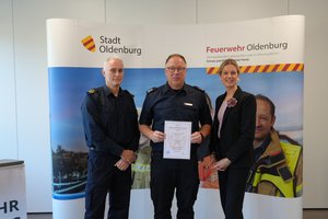 Erste Stadträtin Dr. Julia Figura und Amtsleiter Jens Spekker gratulieren dem Leiter der Höhenrettung Jens Kühling. Foto: Stadt Oldenburg