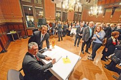Oberbürgermeister Jürgen Krogmann und sein Amtskollege Gilles Bourdouleix, der sich in das Gästebuch eingträgt. Im Hintergrund die Gäste des Empfangs. Foto: Torsten von Reeken