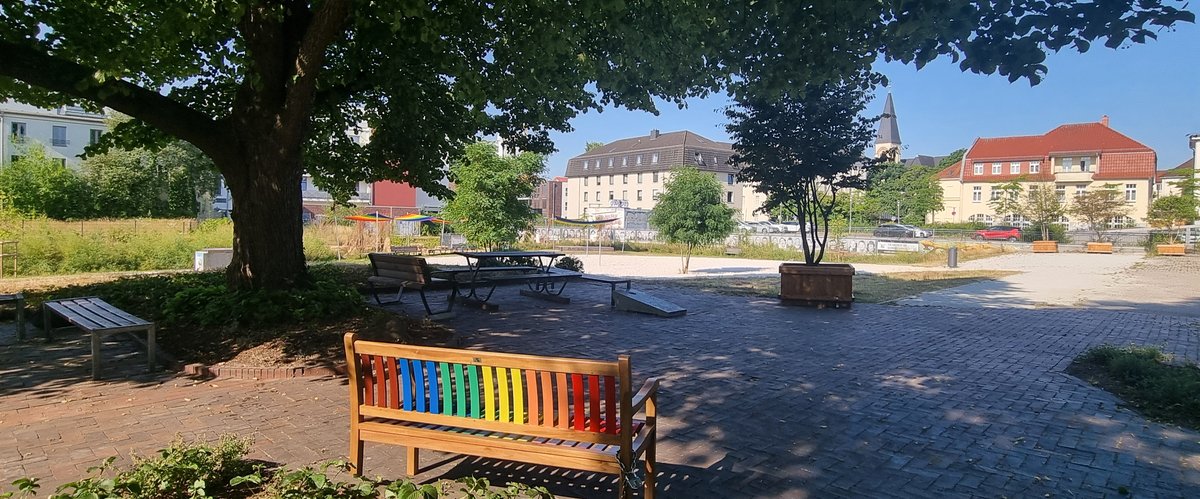 Eine der Regenbogenbänke im Heiligengeistpark, im Hintergrund sind die regenbogenfarbenen Sonnensegel zu sehen. Foto: Stadt Oldenburg