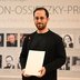 Vorschau: Igor Levit steht vor der Messewand der Carl-von-Ossietzky Preisträgerinnen und Preisträger. Foto: Mohssen Assanimoghaddam
