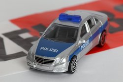 Spielzeug-Polizeiauto auf Absperrband. Foto: Tim Reckmann