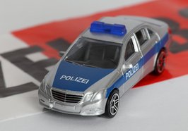 Spielzeug-Polizeiauto auf Absperrband. Foto: Tim Reckmann