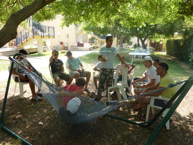 Zwei Jungen liegen in einer Hängematte, davor sitzen weitere Jugendliche auf Gartenstühlen. Foto: Stadt Oldenburg