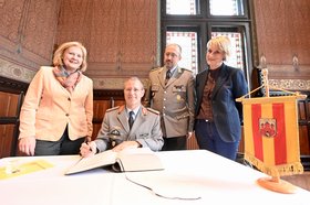 Joachim Hoppe (2. von links) trägt sich ins Gästebuch der Stadt ein. Links neben ihm Bürgermeisterin Petra Averbeck. Foto: Sascha Stüber
