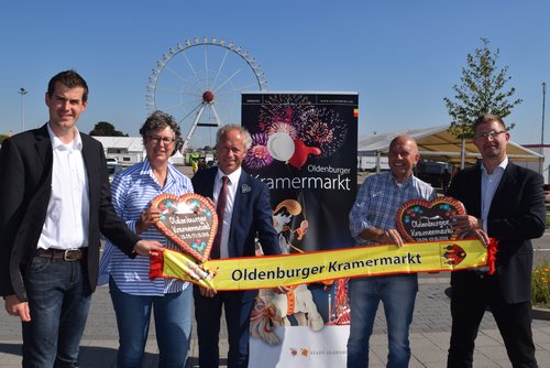 Das Riesenrad im Rücken: (von links) Marktmeister Kersten Mittwollen, Erste Stadträtin Silke Meyn, Amtsleiter Ralph Wilken, Schausteller-Chef Michael Hempen und Fachdienstleiter Christian Aster werben für den Kramermarkt. Foto: Stadt Oldenburg