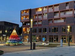Das Foto zeigt den Neubau auf dem Klingenbergplatz und ein Tipi auf dessen Vorplatz, das Ergebnis des Projektes „Ein Tipi für Oldenburg“ ist. Foto: Stadt Oldenburg