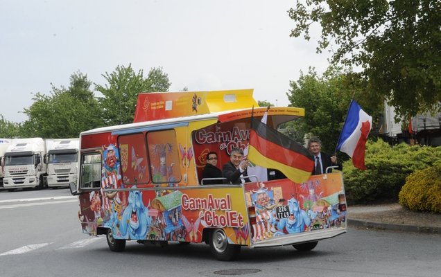 Der Bürgermeister von Cholet, Gilles Bourdouleix, und Gerd Schwandner fahren fahnenschwenkend in die Stadt. Foto: Etienne Lizambard