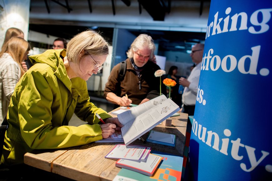 Eine Dame liest in der Broschüre „ISEK Zukunft 2050“ und schreibt ihre Anmerkung auf einem Zettel. Foto: Hauke-Christian Dittrich