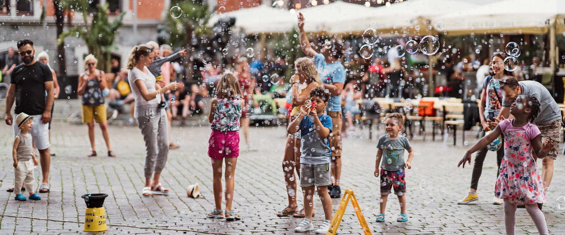 Kinder und Erwachsene machen auf dem Rathausplatz Seifenblasen. Foto: Mittwollen und Gradetchliev