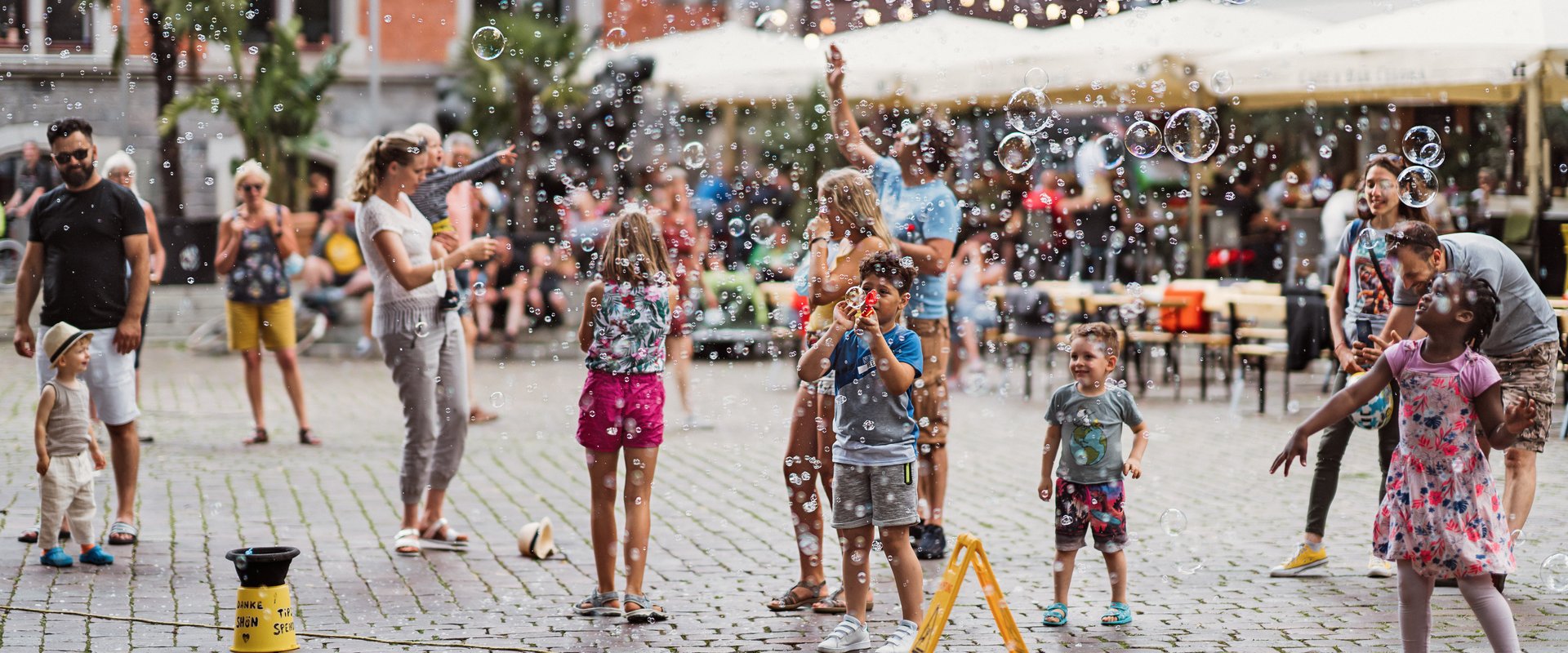Kinder und Erwachsene machen auf dem Rathausplatz Seifenblasen. Foto: Mittwollen und Gradetchliev