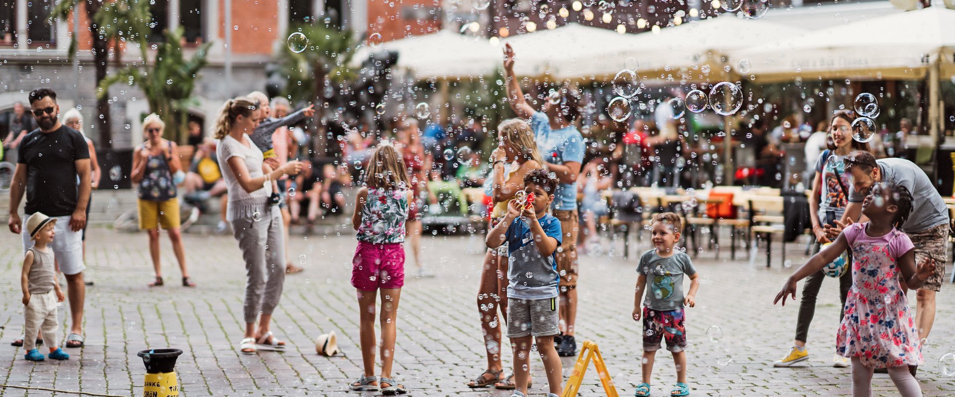 Kinder und Erwachsene machen auf dem Rathausplatz Seifenblasen. Foto: Mittwollen und Gradetchliev