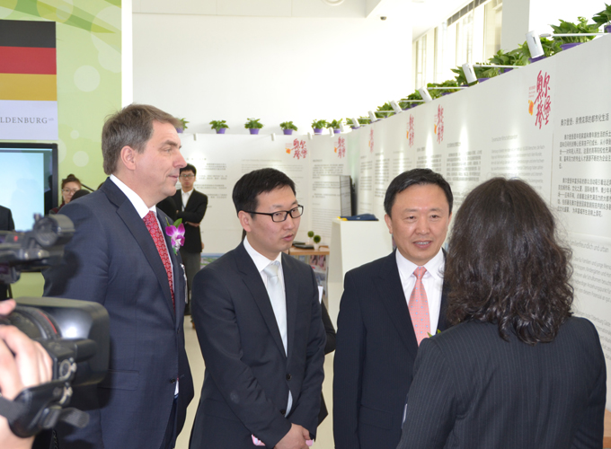 Oberbürgermeister Krogmann im Gespräch mit zwei Personen, an der Wand sind Ausstellungstafeln über Oldenburg zu sehen. Foto: Stadt Oldenburg
