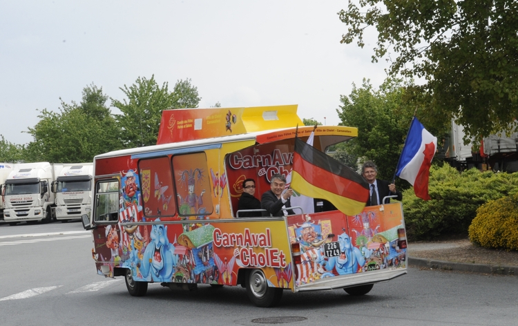Der Bürgermeister von Cholet, Gilles Bourdouleix, und Gerd Schwandner fahren fahnenschwenkend in die Stadt. Foto: Etienne Lizambard