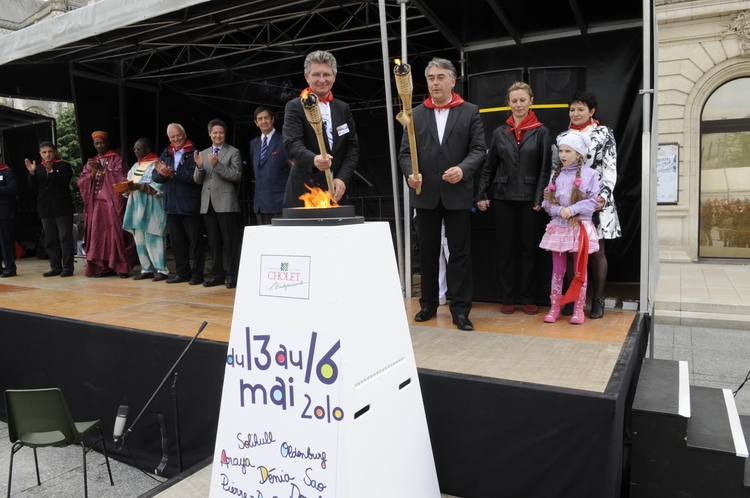 Gilles Bourdouleix und Gerd Schwandner entzünden gemeinsam das Eröffnungsfeuer des Freundschaftstreffens mithilfe von großen Fackeln. Foto: Etienne Lizambard