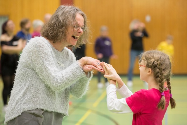 Eine Frau tanzt ausgelassen mit einem Mädchen. Foto: Jörg Sarbach