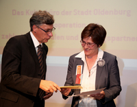 Lutz Stroppe (l.) überreicht Projektleiterin Christiane Maaß die Preisträgerurkunde. Bild: Lars Kreyssig